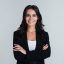 Perfect business lady. Beautiful young businesswoman looking at camera with smile while standing against white background